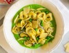 Tortellini with prosciutto on creamed peas and parmesan shavings